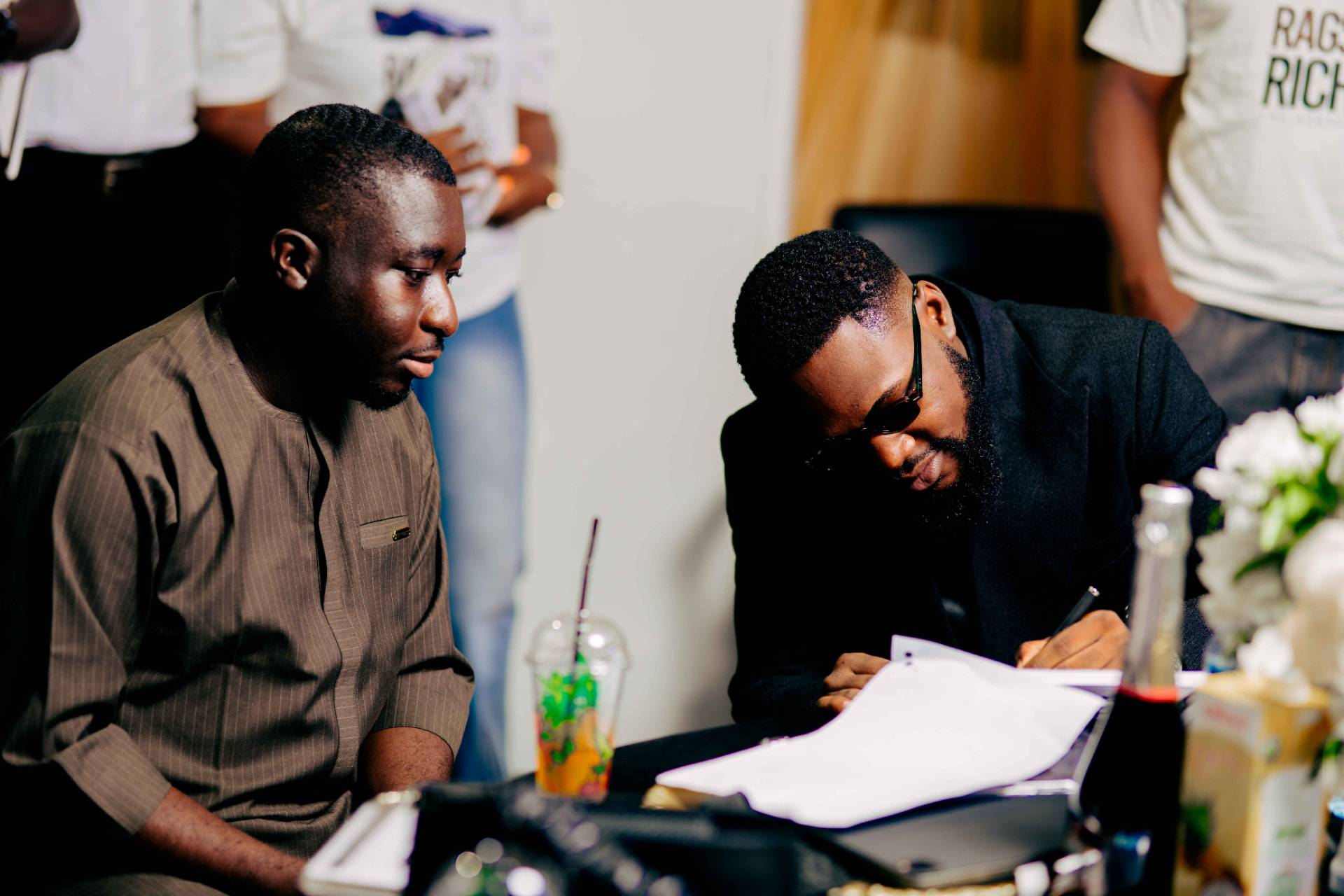 M.N. Onyeachor signing a copy of the book for a guest at the signing table